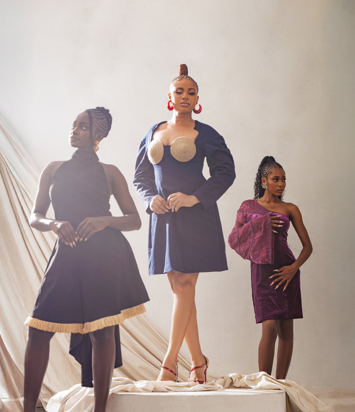 Three models wearing different outfits on a neutral background