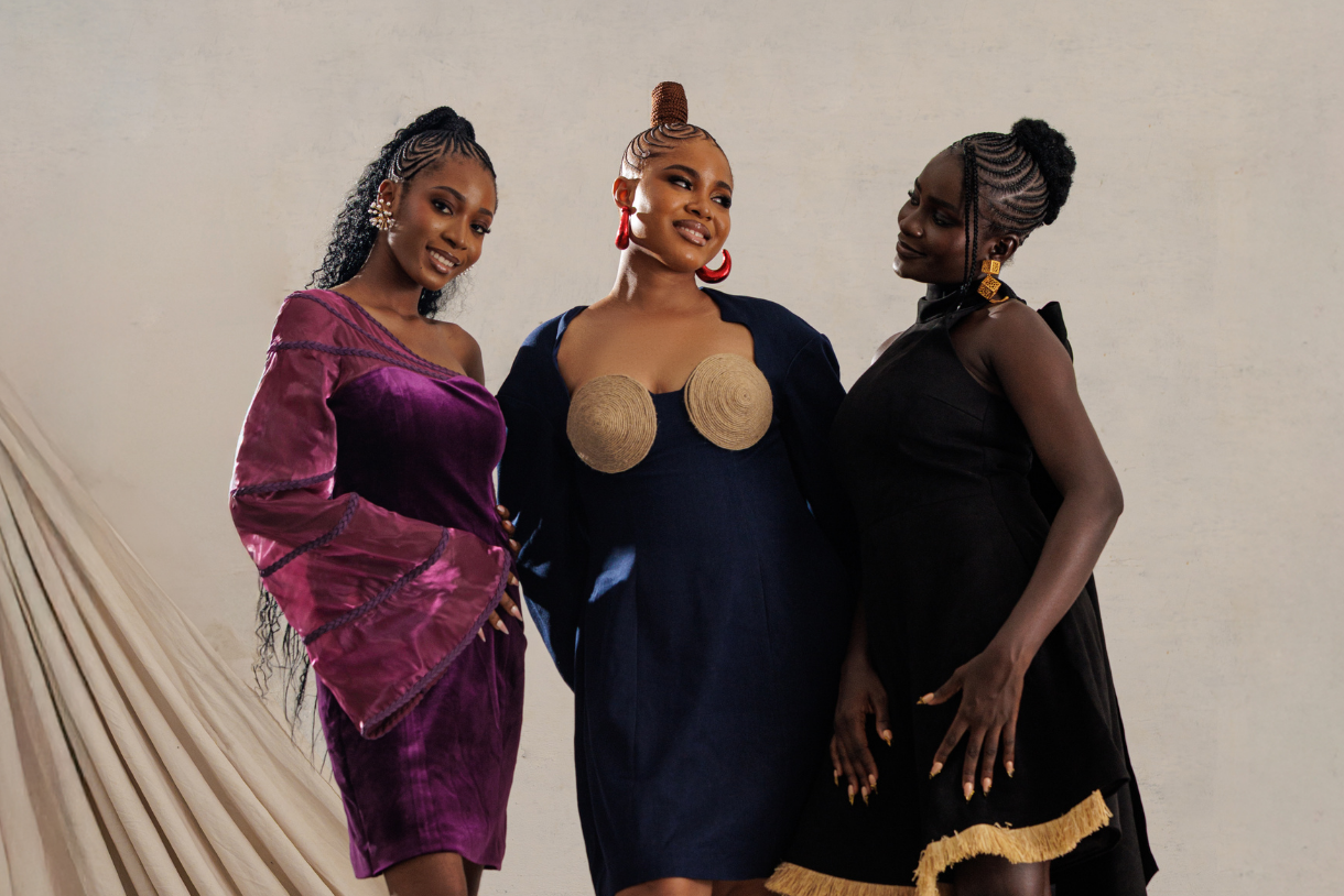 Three women posing together against a plain background